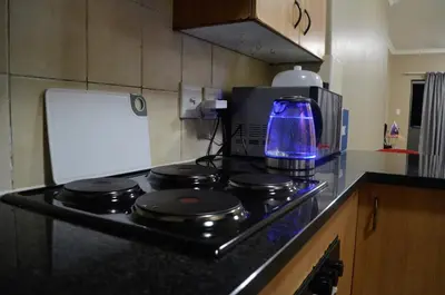 a kitchen with a stove with a blue light on it at Oasis Home in Midrand