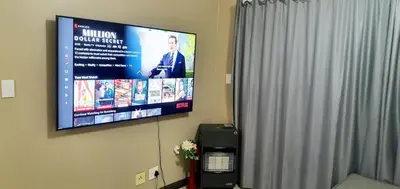 a television hanging on a wall in a room at Oasis Home in Midrand