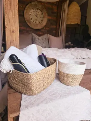 two baskets sitting on top of a bed with a clock at The Blue Shutter Guest House in Haenertsburg