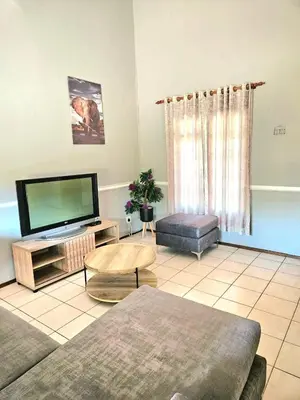 a living room with a couch and a tv at Bela Bela Pendleberry Grove 52 in Bela-Bela