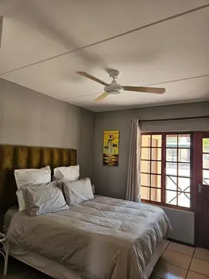 a bedroom with a bed with a ceiling fan at Bela Bela Pendleberry Grove 52 in Bela-Bela