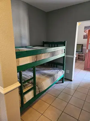 two green bunk beds in a room with a wall at Bela Bela Pendleberry Grove 52 in Bela-Bela