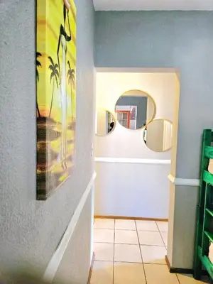 a bathroom with two mirrors and a tile floor at Bela Bela Pendleberry Grove 52 in Bela-Bela