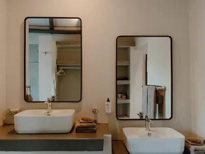 a bathroom with two sinks and a large mirror at Leopard's Bend Bush Lodge in Hoedspruit
