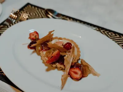 a plate with a dessert with strawberries and nuts at Leopard's Bend Bush Lodge in Hoedspruit