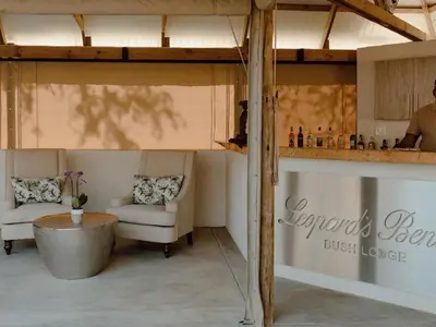 a living room with two chairs and a table at Leopard's Bend Bush Lodge in Hoedspruit