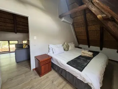 a bedroom with a large bed and a couch at Mbekka Lodge, Mabalingwe in Moheme