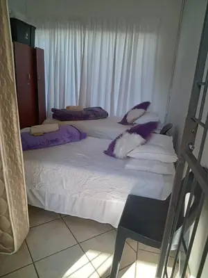 two beds in a room with purple pillows on them at Willmore Guesthouse and Accommodation in Mokopane