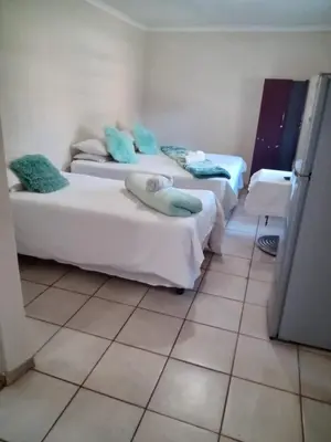 two beds in a room with a tiled floor at Willmore Guesthouse and Accommodation in Mokopane
