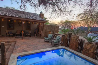 a swimming pool in front of a house at Wild Whispers in Marloth Park