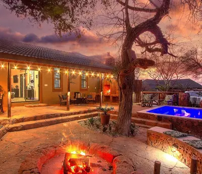 a house with a fire pit in the yard at Wild Whispers in Marloth Park