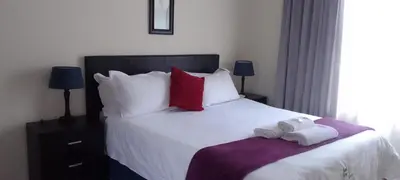 a bedroom with a bed with two towels on it at Sand River Cottages in Hazyview