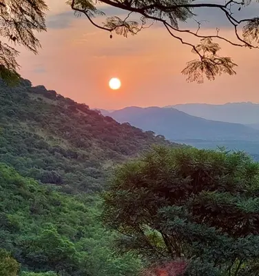 a sunset in the mountains with the sun setting at Nguni Rest in Barberton