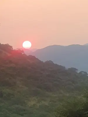 a sunset in the mountains with the sun setting at Nguni Rest in Barberton