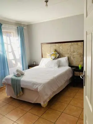 a bedroom with a large bed and a window at Nteto guesthouse in Dwarsloop