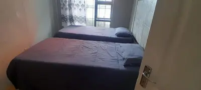two beds in a small room with a window at Nteto guesthouse in Dwarsloop
