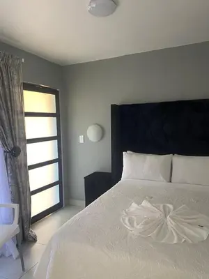 a bedroom with a large white bed with a window at 606 Guesthouse in Bushbuckridge