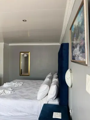 a bedroom with a bed and a blue couch at 606 Guesthouse in Bushbuckridge