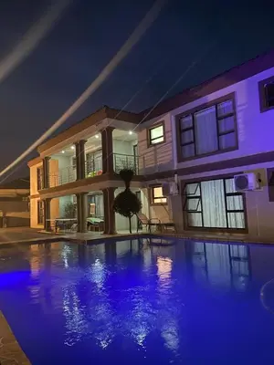 a large house with a swimming pool at night at 606 Guesthouse in Bushbuckridge
