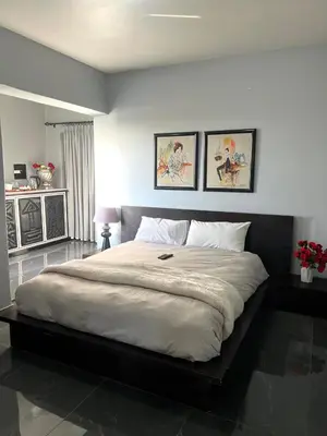 a bedroom with a large bed with two pictures on the wall at The Concept in Centurion