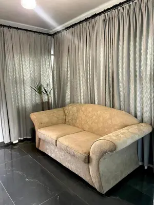 a couch sitting in a living room with curtains at The Concept in Centurion