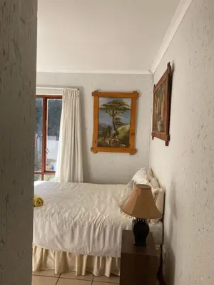 a bedroom with a bed and a window and a lamp at Stay in Woodhill Golf Estate near Pretoria East Hospital in Pretoria