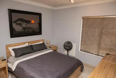 a bedroom with a bed and a window at Premium Deluxe at waterkloof in Pretoria