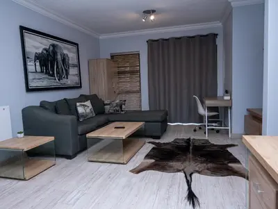 a living room with a couch and a table at Premium Deluxe at waterkloof in Pretoria