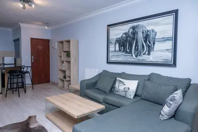 a living room with a couch and a picture of elephants at Premium Deluxe at waterkloof in Pretoria