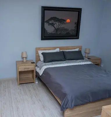 a bedroom with a bed and two nightstand tables at Premium Deluxe at waterkloof in Pretoria