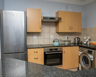 a kitchen with a stainless steel refrigerator and a dishwasher at Premium Deluxe at waterkloof in Pretoria