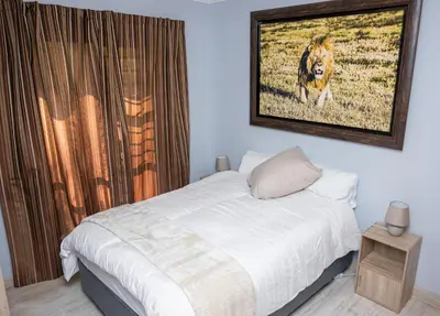 a bedroom with a bed with a picture on the wall at Premium Deluxe at waterkloof in Pretoria