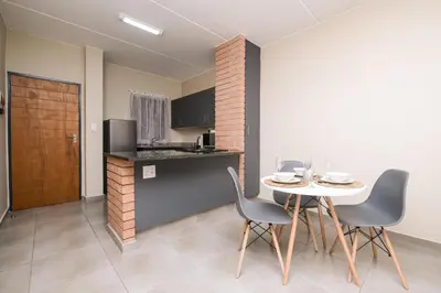 a kitchen and dining room with a table and chairs at Mkhonto's waterfall ridge in Midrand