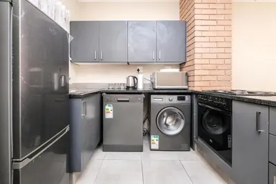 a kitchen with a washing machine and a washer and dryer at Mkhonto's waterfall ridge in Midrand