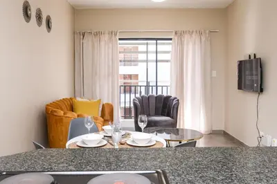 a kitchen and living room with a table and chairs at Mkhonto's waterfall ridge in Midrand
