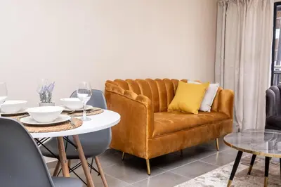 a living room with a couch and a table at Mkhonto's waterfall ridge in Midrand