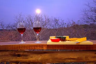 two glasses of wine sitting on a wooden table at Longneck Luxury Bush Lodge in Marloth Park