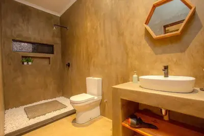 a bathroom with a white toilet and a sink at Longneck Luxury Bush Lodge in Marloth Park