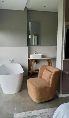 a bathroom with a tub and a chair and a sink at The Views at 492 Euphoria Golf Estate in Naboomspruit
