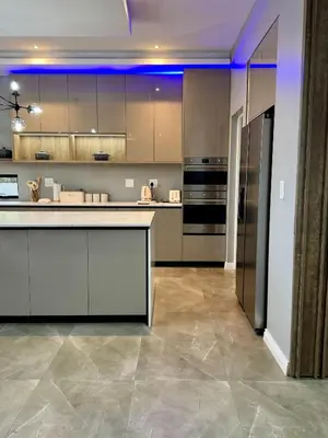a large kitchen with stainless steel appliances and purple lighting at The Views at 492 Euphoria Golf Estate in Naboomspruit
