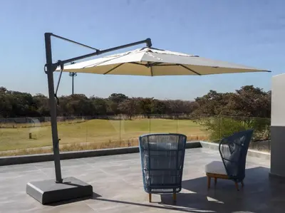 a large umbrella on a patio with a golf course at The Views at 492 Euphoria Golf Estate in Naboomspruit