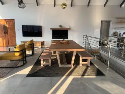 a dining room with a wooden table and chairs at Hururu House in Dullstroom