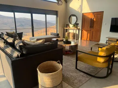 a living room with a couch and a table at Hururu House in Dullstroom