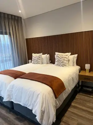 a hotel room with two beds and a window at Hururu House in Dullstroom