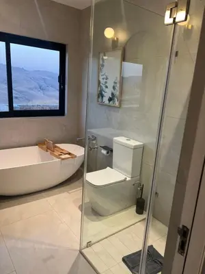 a bathroom with a shower and a toilet and a tub at Hururu House in Dullstroom