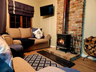 a living room with a couch and a fireplace at Fairstreams Nr3 in Dullstroom