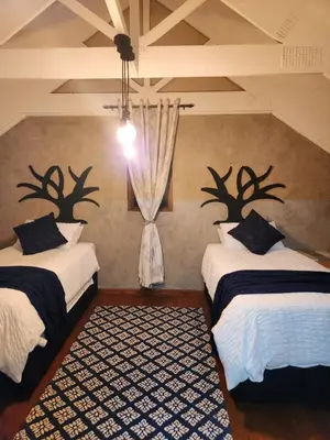 a bedroom with two beds with antlers on the wall at Fairstreams Nr3 in Dullstroom