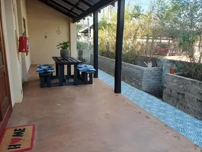 a patio with a table and two stools on it at Fairstreams Nr3 in Dullstroom