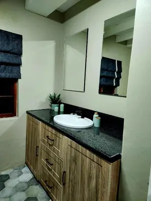 a bathroom with a sink and a mirror at Fairstreams Nr3 in Dullstroom