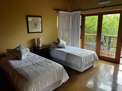 two beds in a bedroom with a balcony at Mokaikai - Elephants Crossing - Moi Exclusive Luxury Villa in Mabula